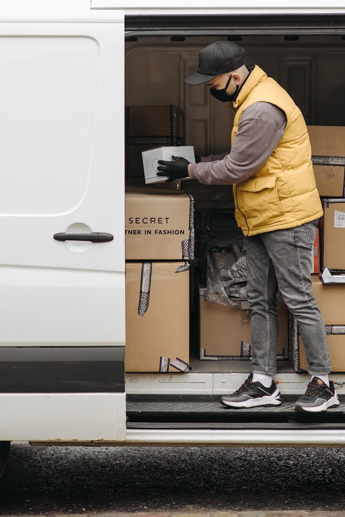 why-choose-us Deliveryman arranging packages in white van for efficient distribution.